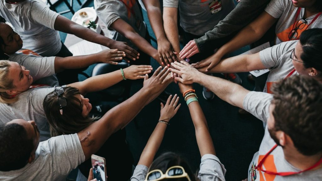 Diverse group of people joining hands in the center