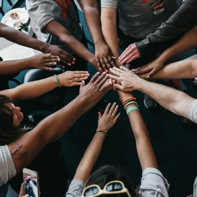 Diverse group of people joining hands in the center