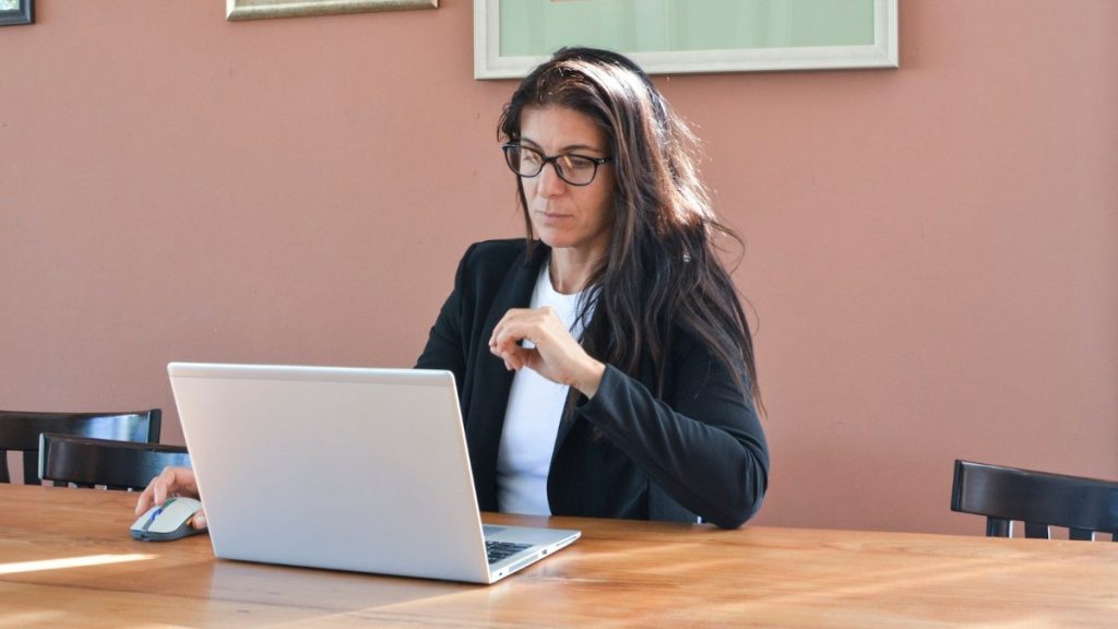 An experienced professional woman working at a laptop in an office