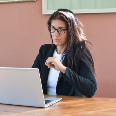 An experienced professional woman working at a laptop in an office