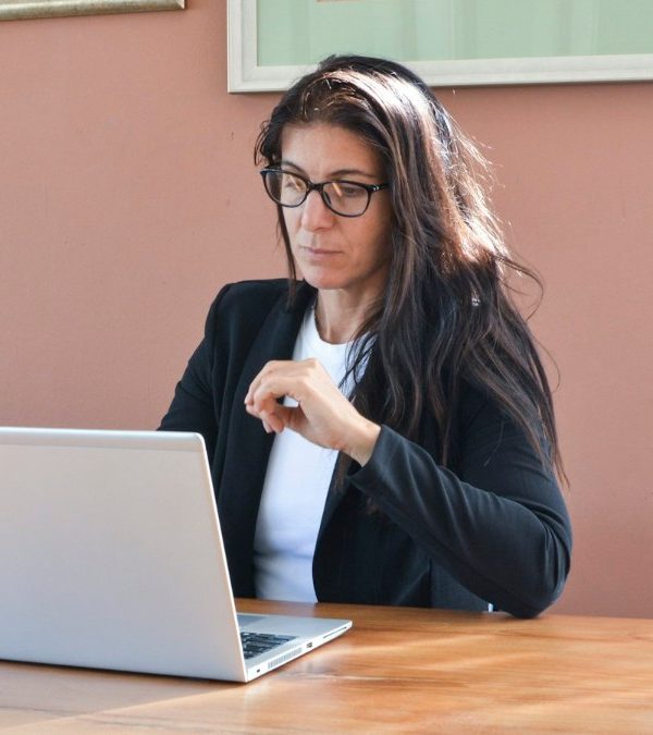 An experienced professional woman working at a laptop in an office
